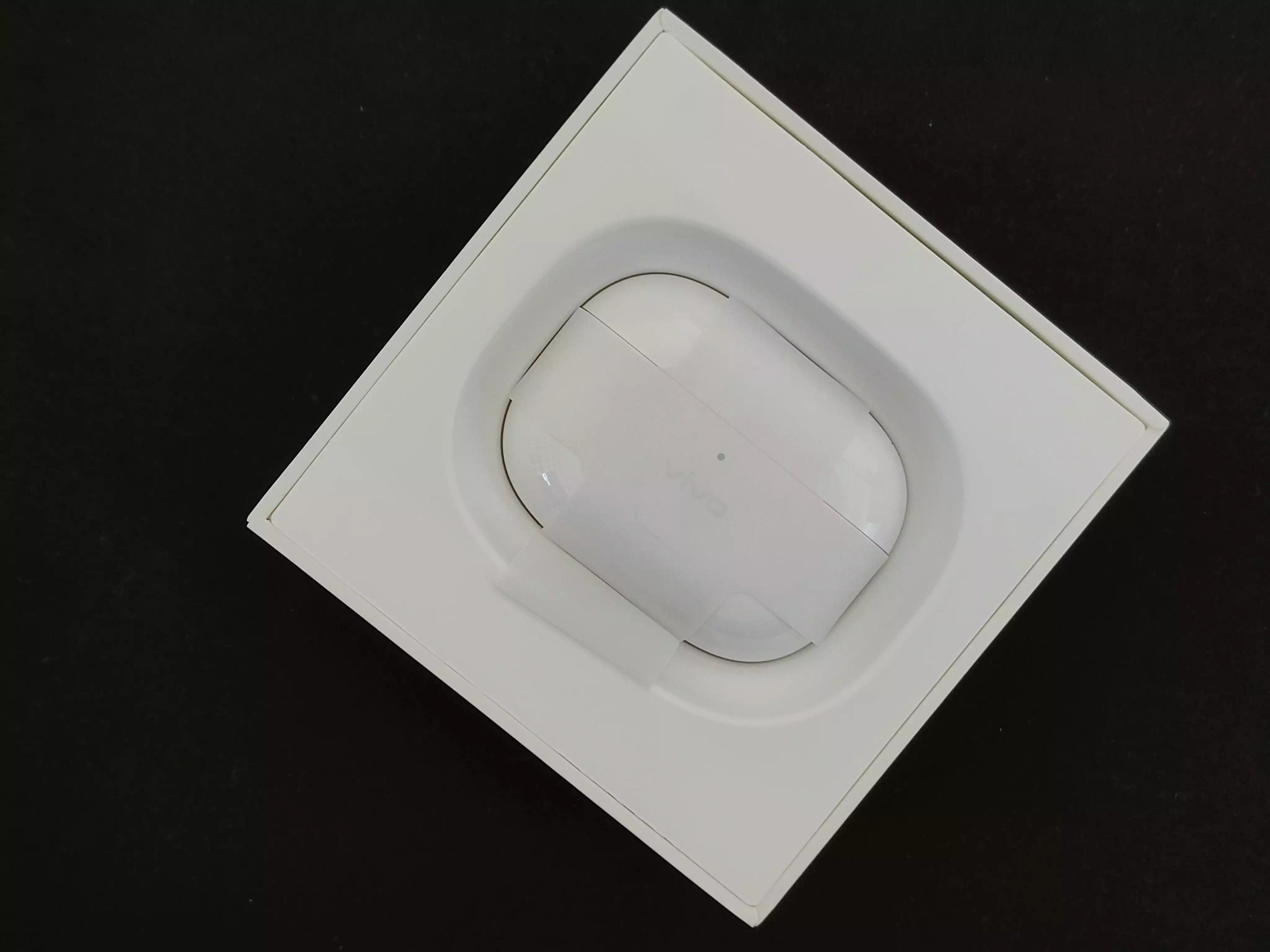 打开耳机里面是呈背靠背的样式.耳机正面有呼吸灯和充值按键.